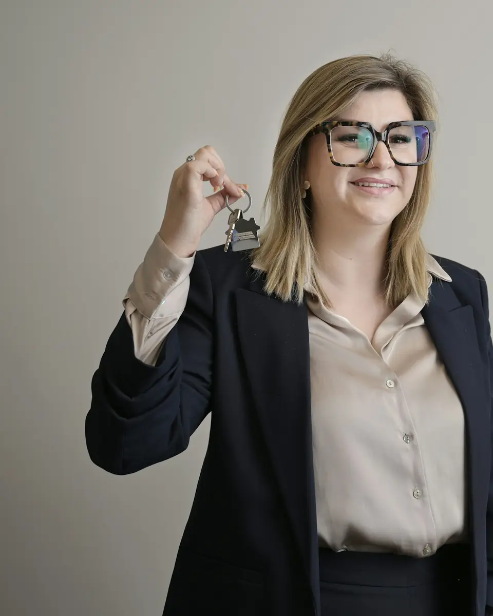 Agente immobiliare sorridente che mostra le chiavi