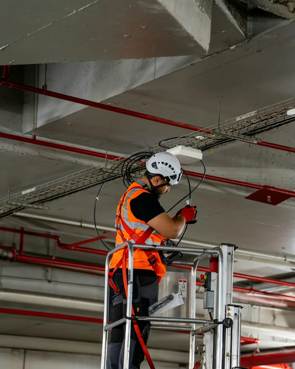 Tecnico su piattaforma che installa componenti a soffitto